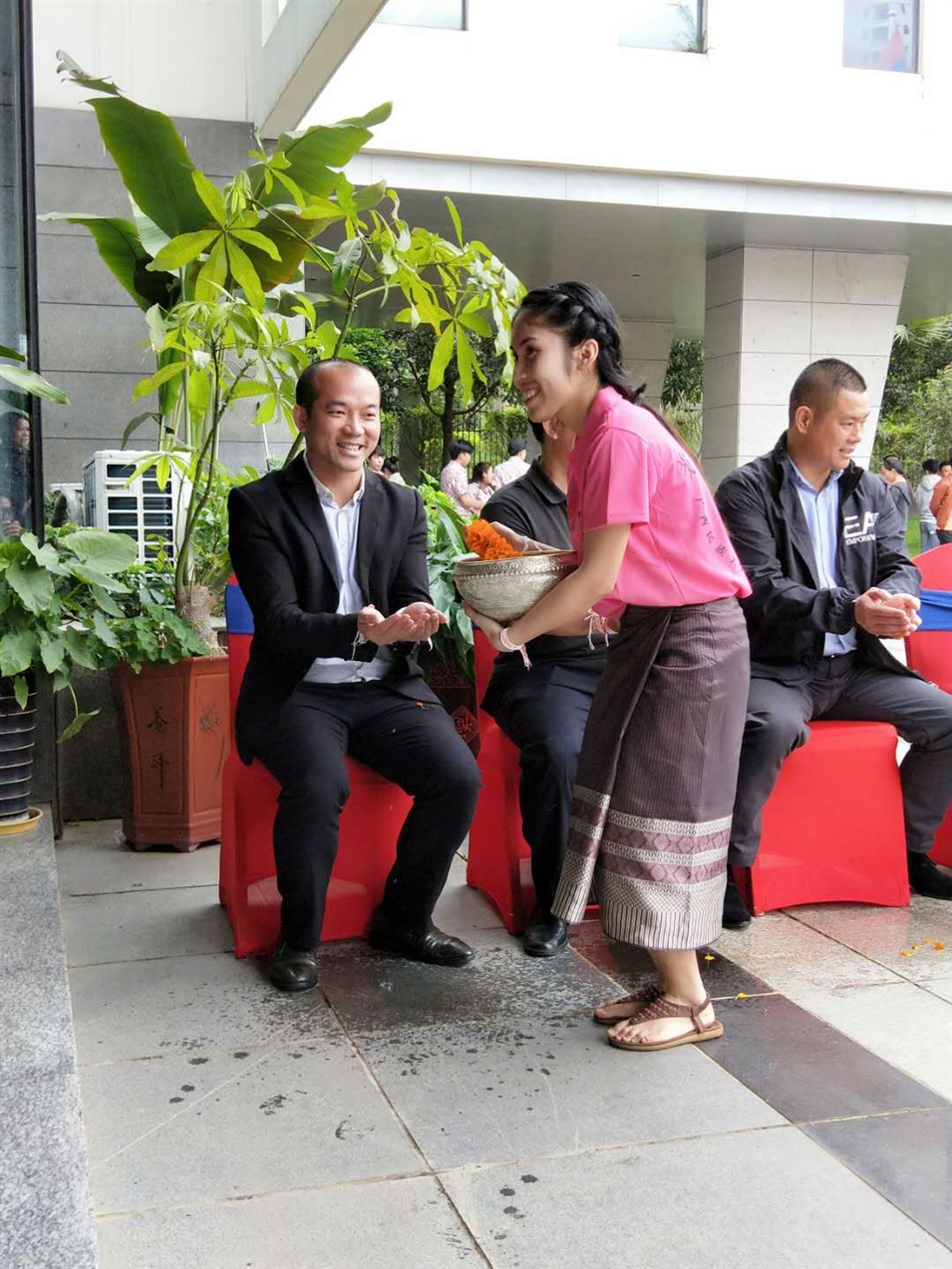 老撾駐廣西留學(xué)生代表將浸有花瓣的香水灑客人的手上，表示對嘉賓的美好祝福（圖一）